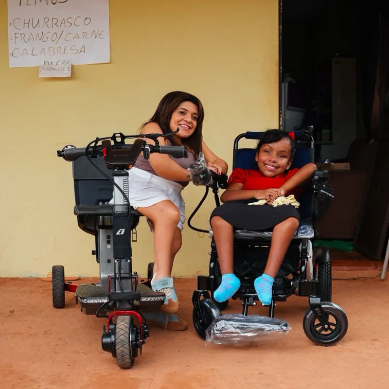 Lorrane Silva ao lado de Samela em sua nova cadeira motorizada